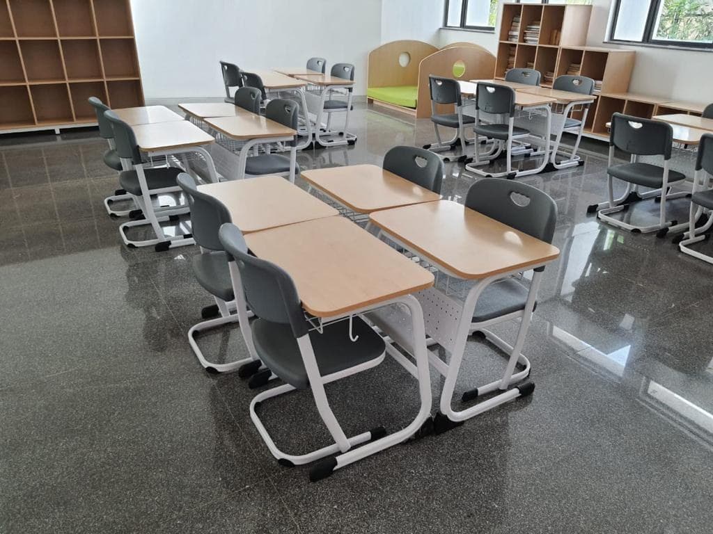 Cantilever desks and grey chairs arranged in a library